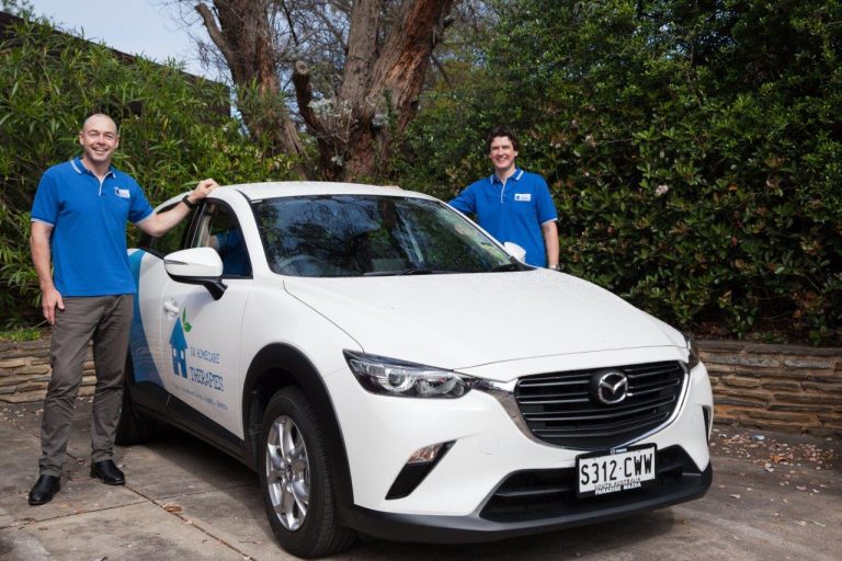 Two of SA Homecare Therapies' mobile physiotherapists standing with a car